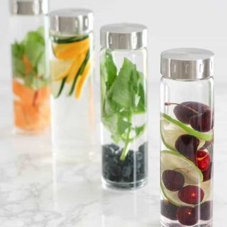 Infused water recipes in 4 glass bottles.