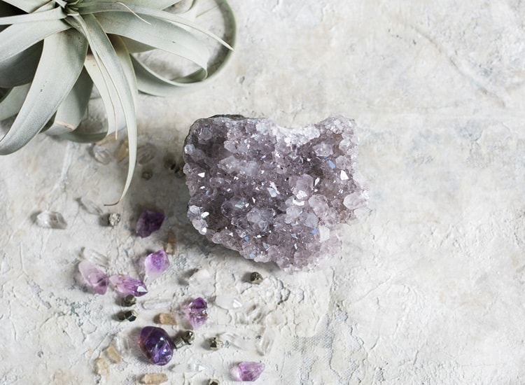 image of amethyst on a grey background with an air plant