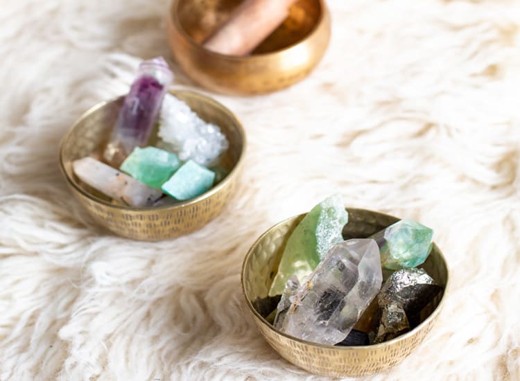 healing crystals on a fur throw in gold bowls