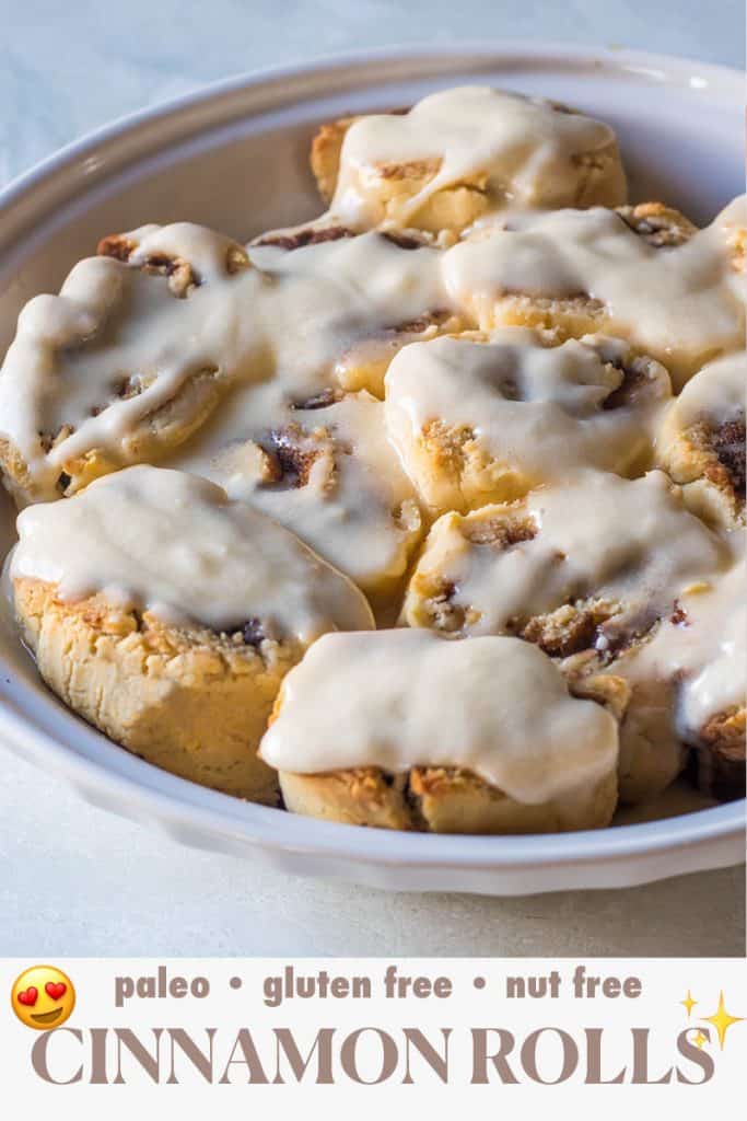 A pie pan of gluten free and paleo cinnamon rolls covered in warm frosting with text below that reads: Paleo, Nut Free, Gluten Free Cinnamon Rolls